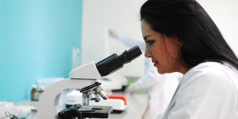Women looking at slide on microscope